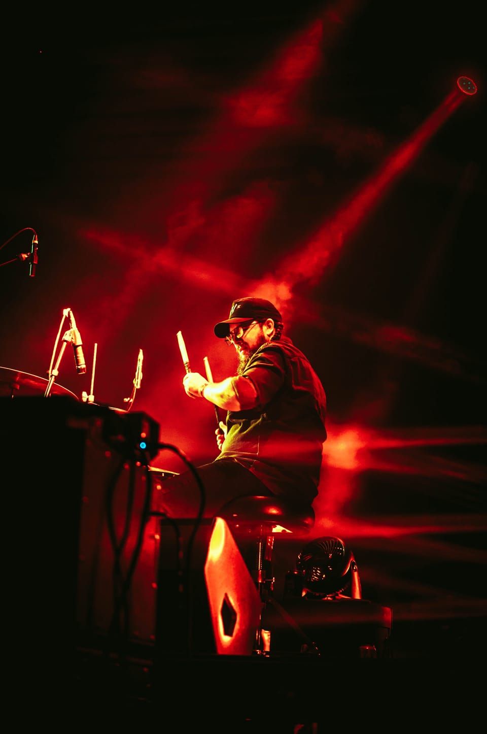 Time Sawyer. A musician behind a keyboard rig is cut across by red beams of light.